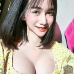 KL Escort Girl Smiling Asian woman in a yellow floral top with black hair. Malaysia Sex Service