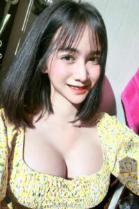 KL Escort Girl Smiling Asian woman in a yellow floral top with black hair. Malaysia Sex Service