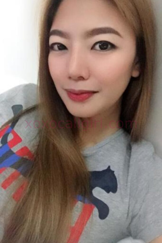 KL Escort Girl Attractive Chinese escort in Kuala Lumpur with long hair, wearing a casual gray top. Malaysia Sex Service