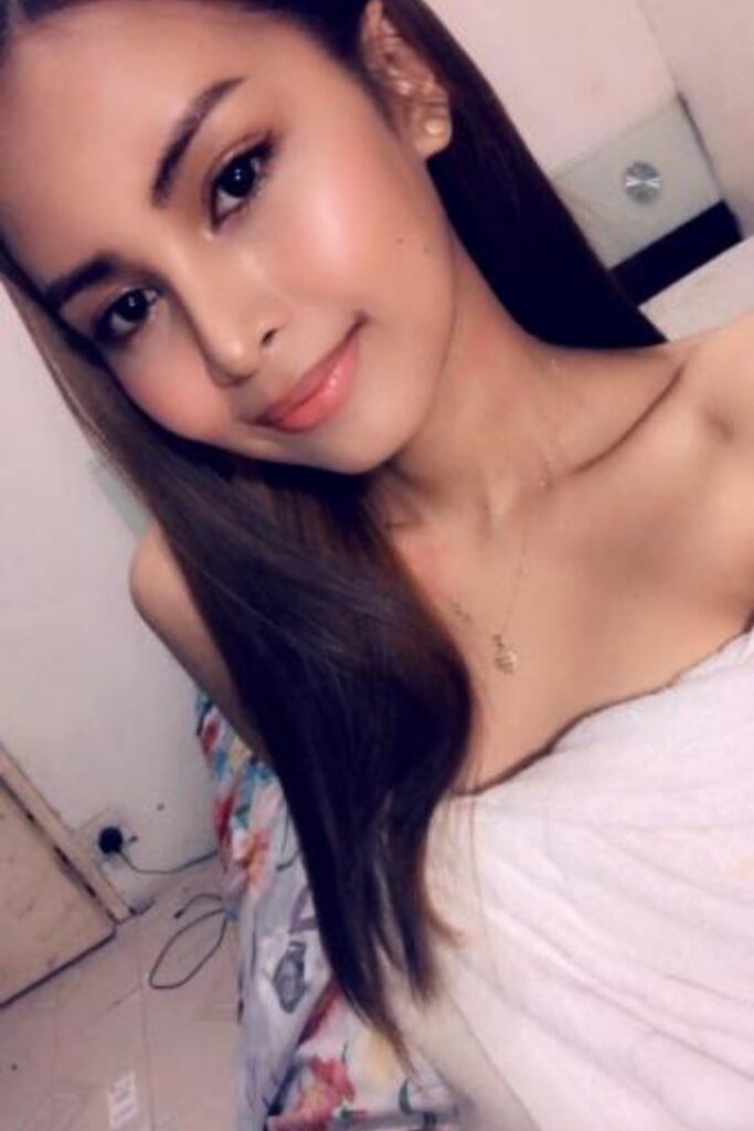 KL Escort Girl Portrait of a beautiful woman with long brown hair and a white top. Malaysia Sex Service