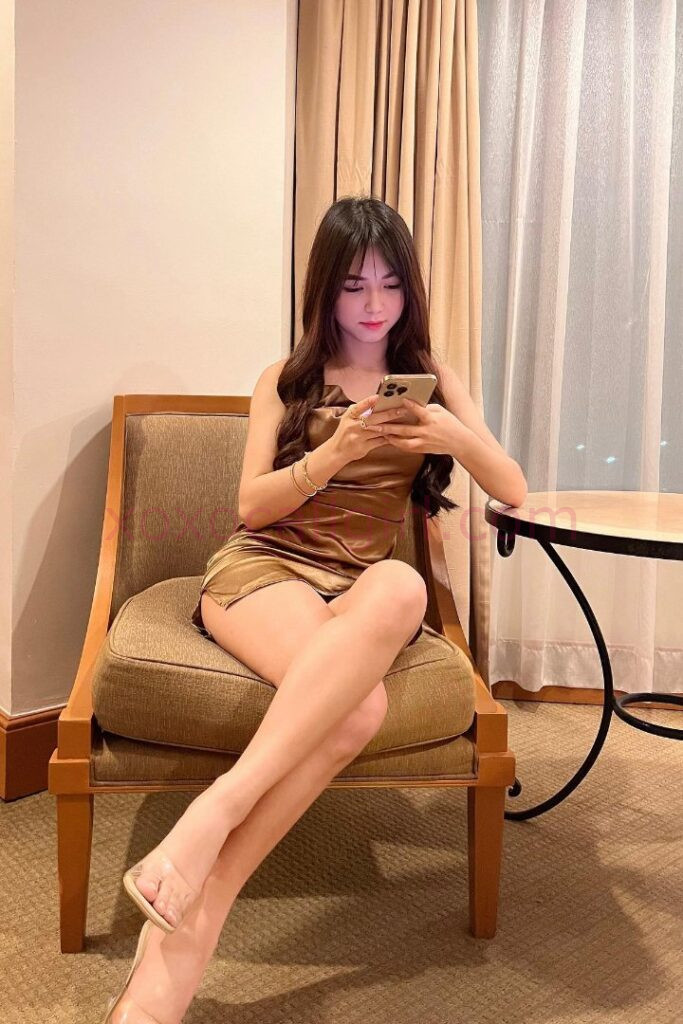 KL Escort Girl Malay Escort in Kuala Lumpur sits and uses her phone. Malaysia Sex Service