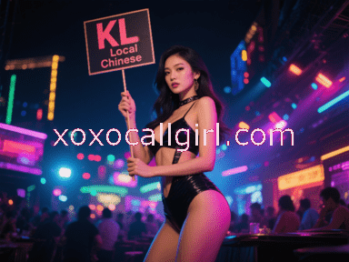 KL Escort Girl Woman in a red and checkered racing-themed outfit poses on a gray couch. Malaysia Sex Service